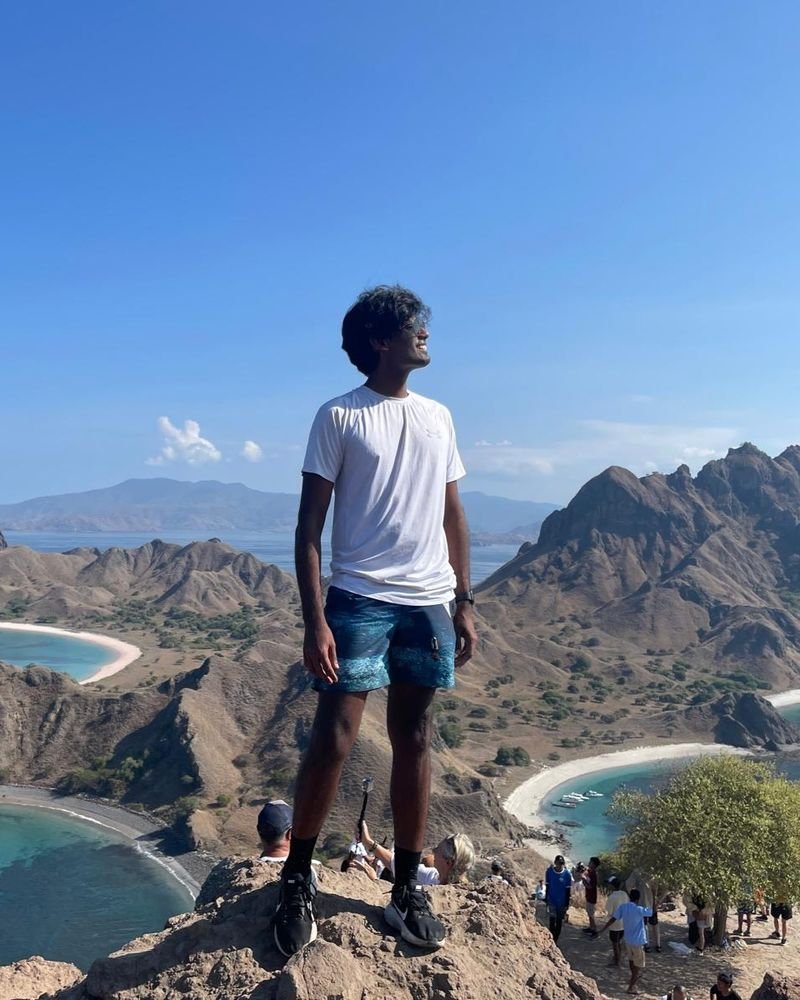 Nandaki standing on a clifftop above turquoise bays